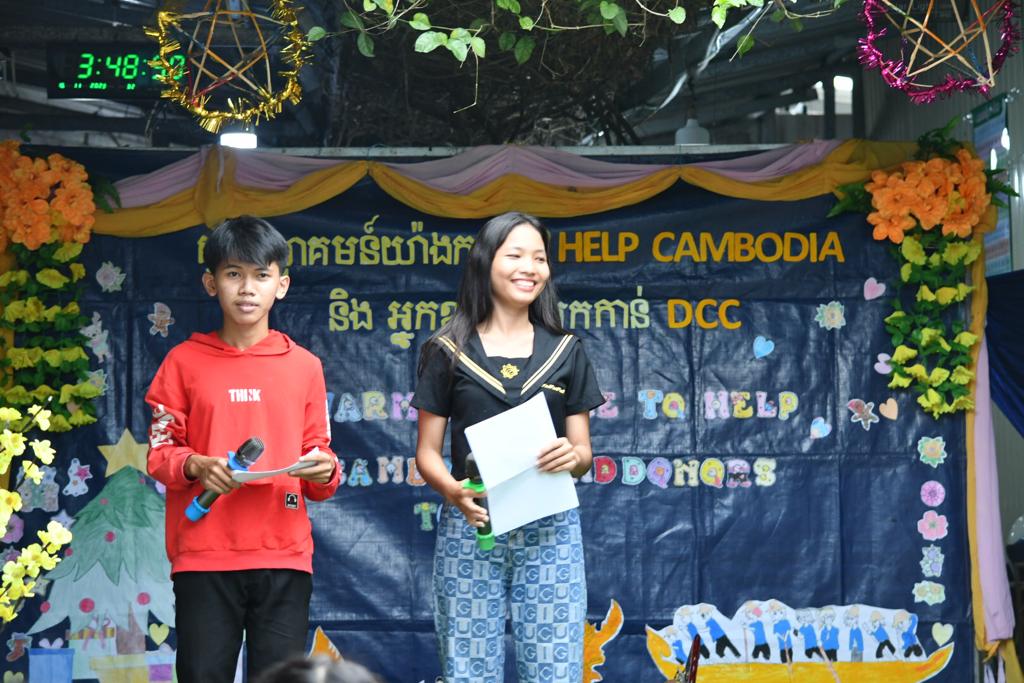 Two DCC students presenting at the welcome event for the HELP Cambodia group